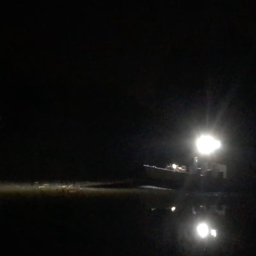 Boot over het water in het donker
