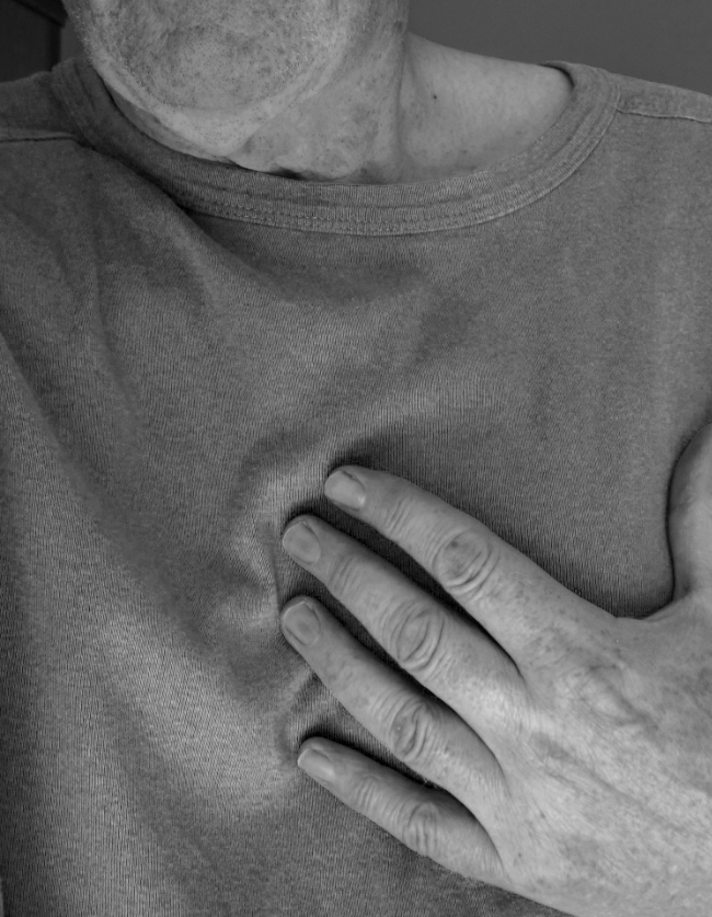 Portretfoto van torso man die hand op zijn hart laat rusten